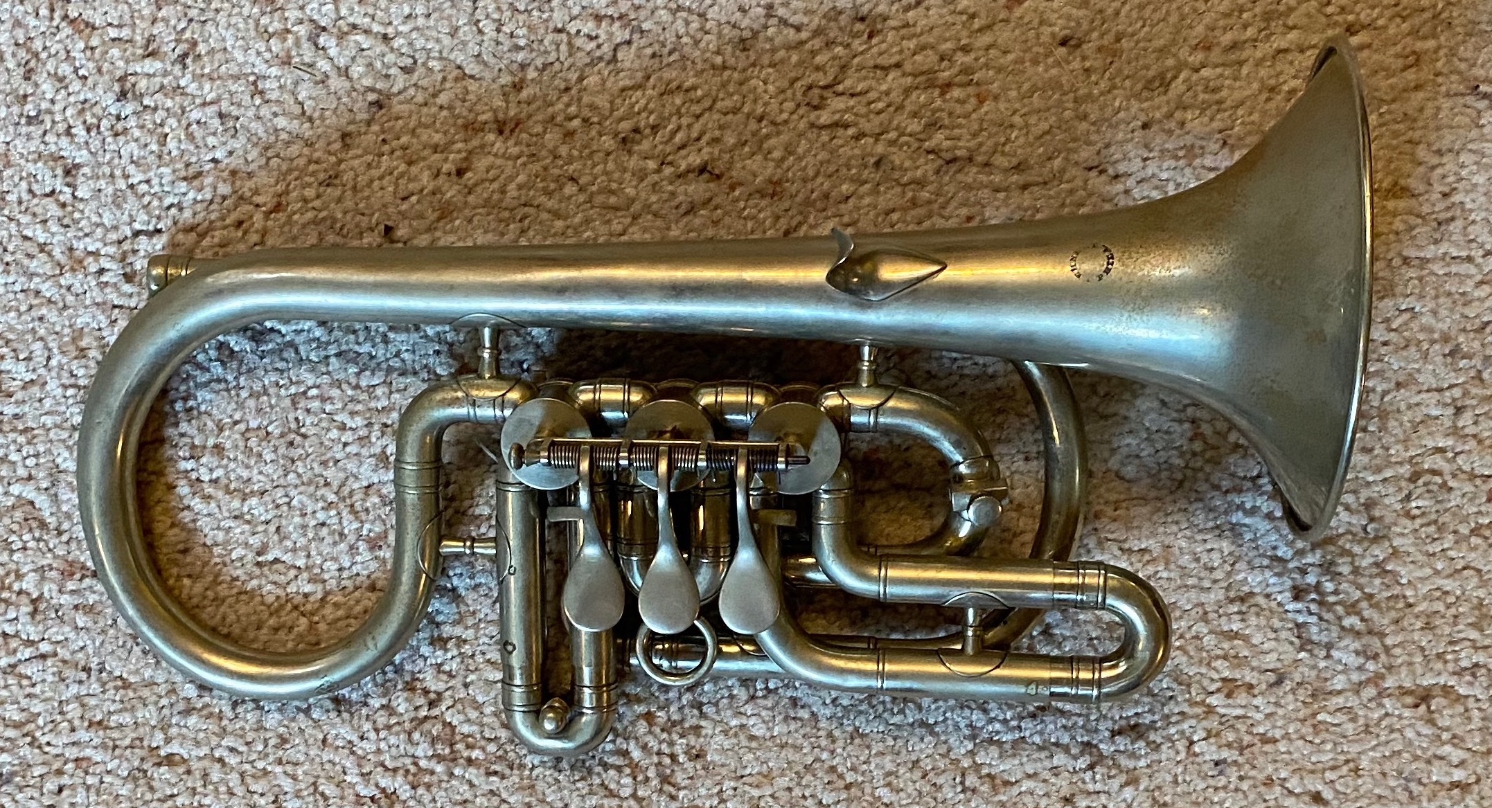 Side action rotary cornet made in German silver. Features a small stamp on the bell that says "Lehnert, Phil."
