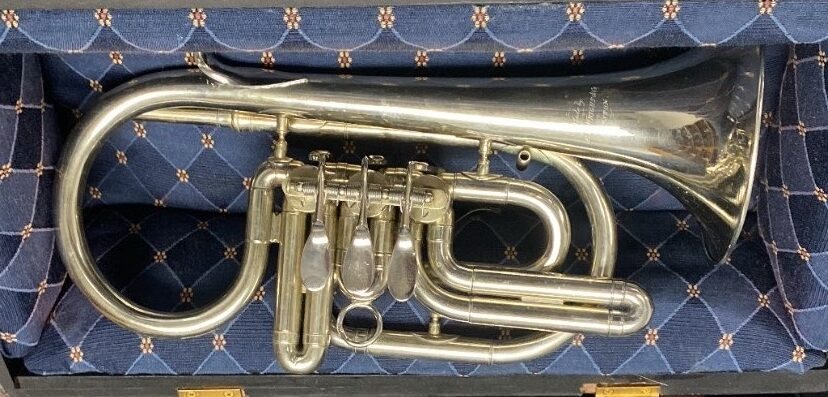 This Bb cornet is silver plated and in a blue-lined wooden case. The instrument features side-action rotary valves.