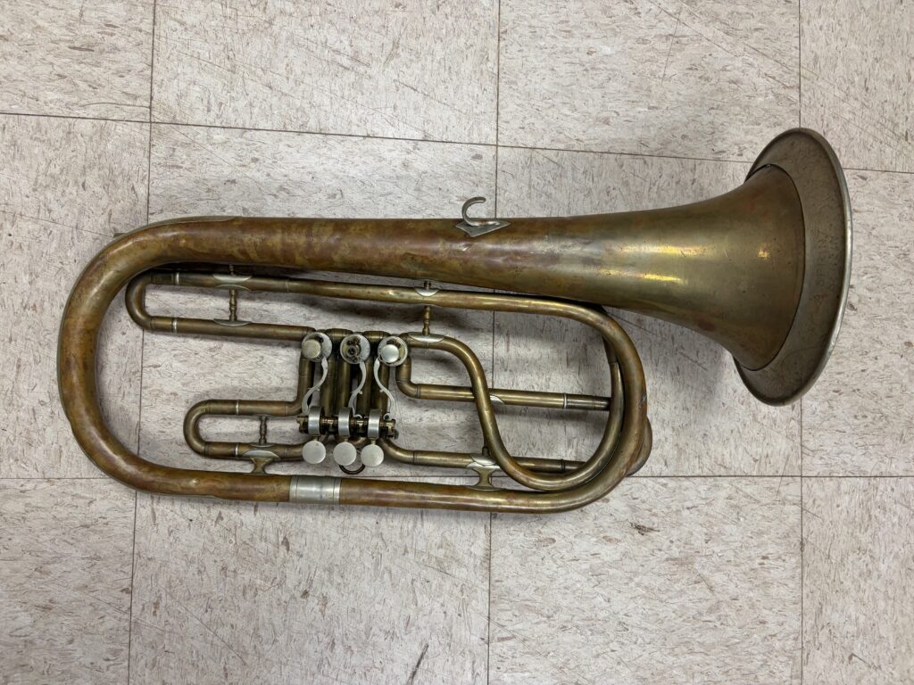 A bell-front baritone made of brass utilizing 3 side-action rotary valves with metal clockwork linkage